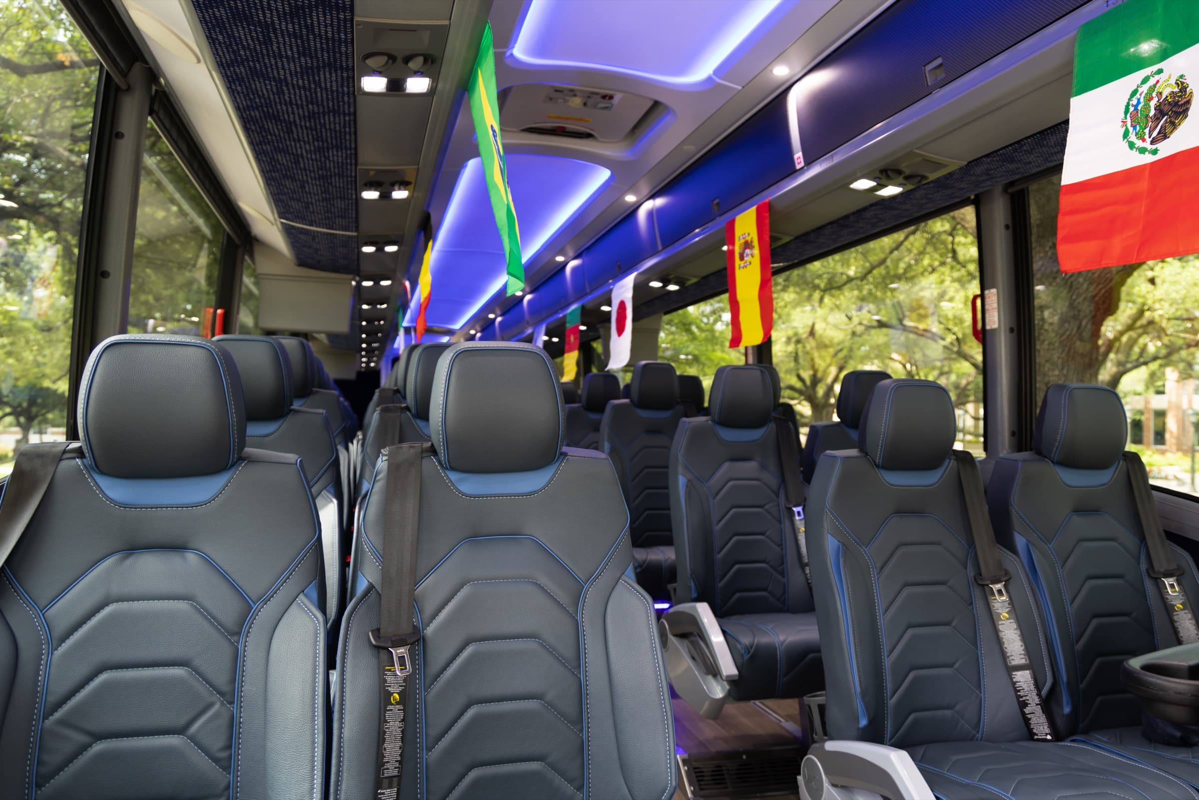 Premium reclining leather seats inside a RYDWAY coach, with national team flags